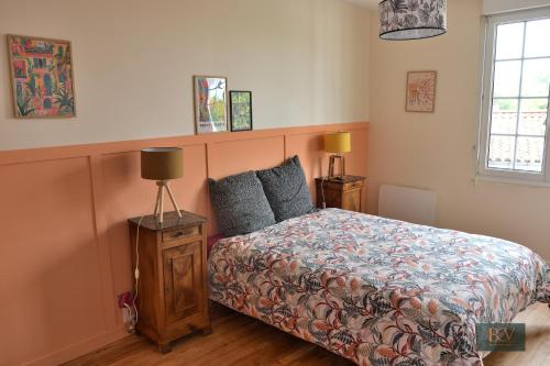a bedroom with a bed and two lamps in it at Le Gîte du Cerisier in Pouzauges