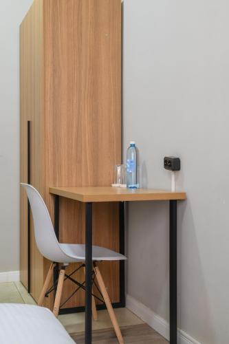 a desk with a white chair next to a table at Uide hotel in Almaty