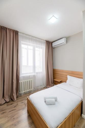 a bedroom with a large bed and a window at Uide hotel in Almaty