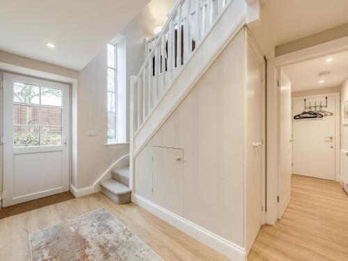 a staircase in a home with white walls at The Stables At Wells-In-The-Field Farm in Whitchurch