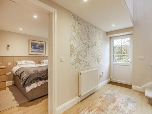 a bedroom with a bed and a window at The Stables At Wells-In-The-Field Farm in Whitchurch
