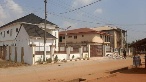 a house on the side of a dirt road at Hog Inn Hotel in Benin City