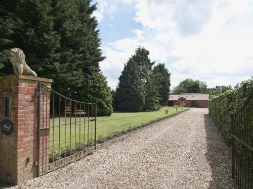 a gate with a dog statue on the side of a driveway at St Andrews Barn in Necton