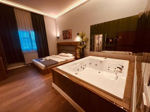a large bathroom with a large tub and a bed at OTTO Boutique in Ankara