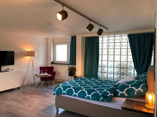 a bedroom with a bed with a blue comforter at R36 - Mainhouse in Wesel