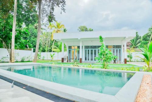 a swimming pool in front of a house at STARK Villa in Talpe