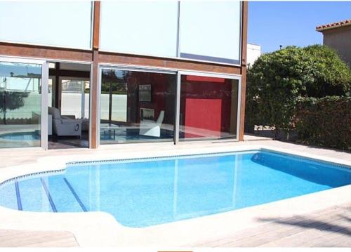 ein Swimmingpool vor einem Haus in der Unterkunft Villa a 100 metros de la playa in Castellón de la Plana