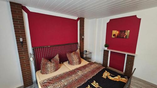 a bedroom with a bed with a red head board at Ferienwohnung Stephan in Berggiesshübel