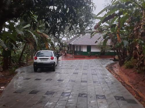 a car parked in a parking lot in front of a house at Ophel homes in Mananthavady