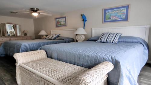 1 dormitorio con 2 camas, silla y ventilador en Escape To Yacht - Upstairs Apartment, en Cape May
