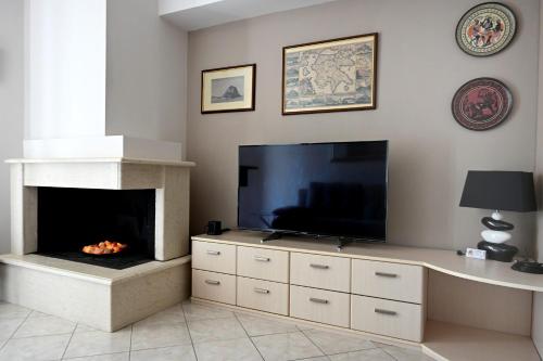 a living room with a fireplace and a flat screen tv at #Leonidas# in Sparti