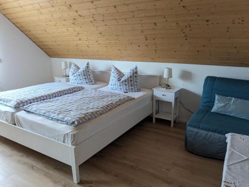 a bedroom with a white bed and a blue chair at Ferienwohnung zum Wohlfühlen in Altensteig