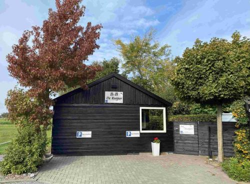 a black garage with a sale sign on it at Bed & Breakfast de Ruijter in Oud-Gastel