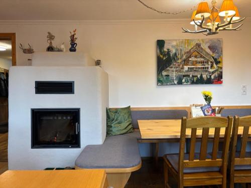 a living room with a table and a fireplace at Gasthaus Moosegg in Lochau