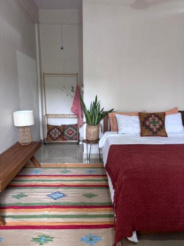 Schlafzimmer mit einem Bett, einem Tisch und einem Teppich in der Unterkunft Drifters Surf Eat Stay in Kappil