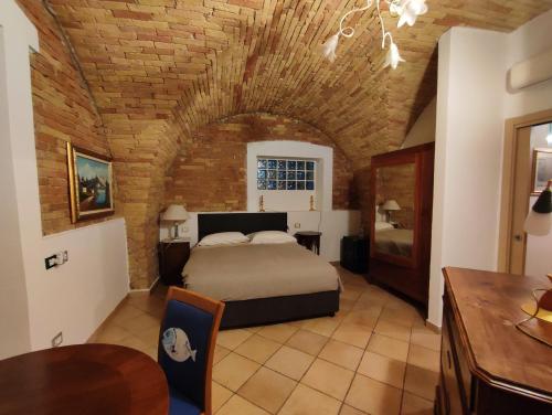 a bedroom with a bed and a table in a room at Le Colline di Castellana in Cerratina