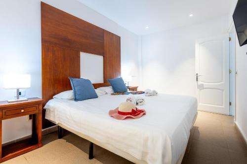 een slaapkamer met een bed met een hoed erop bij LUXURY HOLIDAYS SUITES, Playa de los Cristianos in Los Cristianos