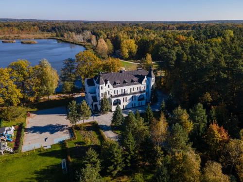 an aerial view of a large house on a lake at Castle Lakes - Apartamenty in Legnica
