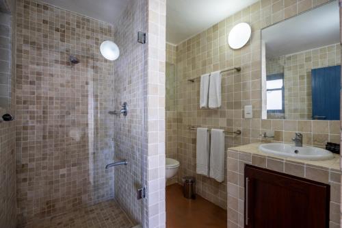 a bathroom with a sink and a toilet and a mirror at Seehuis Studios in Langebaan
