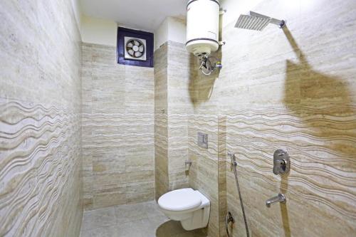 a bathroom with a toilet and a light on the wall at Hotel Blist villa in New Delhi