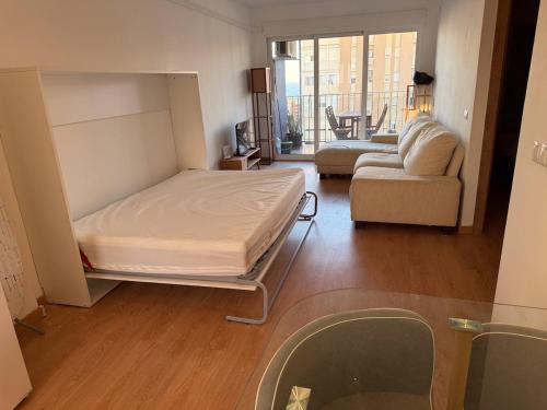 a room with a bed and a living room with a couch at Apartment in 5 Mares development in Puebla de Farnals