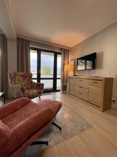 a living room with a couch and a television at Triventi Apartament 2 sypialnie, garaż, blisko Tropikana i wyciąg na Kopę in Karpacz