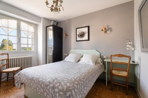 a bedroom with a bed and a desk and a chair at La Mansardière in Cancale