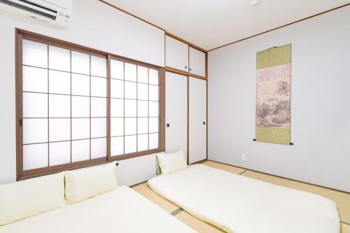 two beds in a room with windows at 頤和小屋 in Osaka
