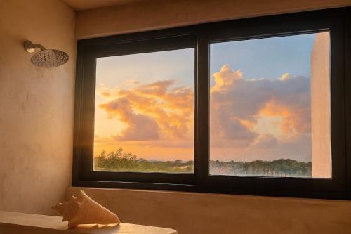 a window with a view of a sunset at Private Jacuzzi, Golf Getaway, sunrise view in Puerto Aventuras