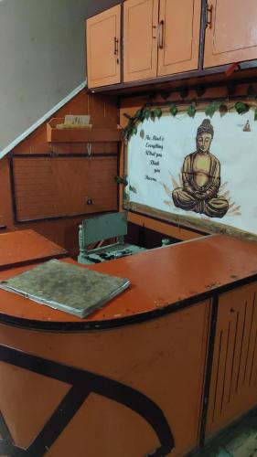 a desk with a poster of a buddha on it at Hotel Vijaya in Mau