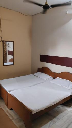 a bedroom with a large bed with white sheets at Hotel Vijaya in Mau