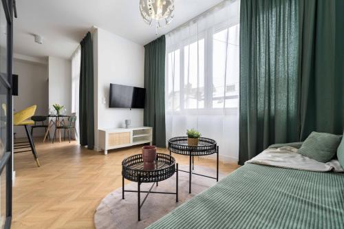 a living room with a bed and two tables at Apartamenty Stojałowskiego 18 in Bielsko-Biala