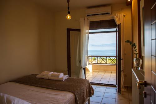 a bedroom with a bed and a view of the ocean at Vista Mare Aegina in Kipséli