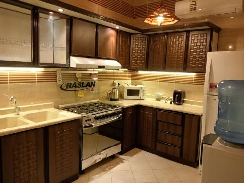 a kitchen with a sink and a stove top oven at موني للشقق الفندقية in Qabāʼ