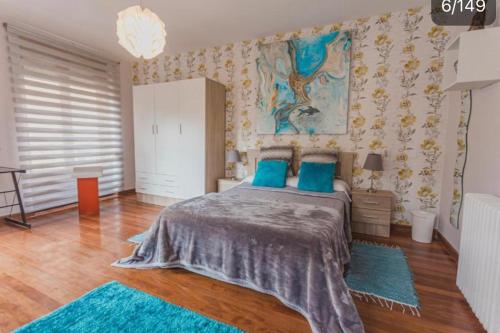 een slaapkamer met een bed met blauwe kussens bij Arquitecto de la Vida - Plaza Mayor in León