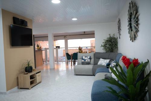 ein Wohnzimmer mit Sofa und Fernseher in der Unterkunft Villa JOLIS 4 chambres avec piscine en Guadeloupe in Les Abymes