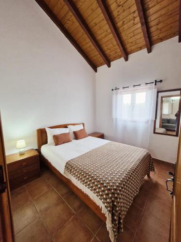 a bedroom with a bed and a window at Casa Silva in Zambujeira do Mar