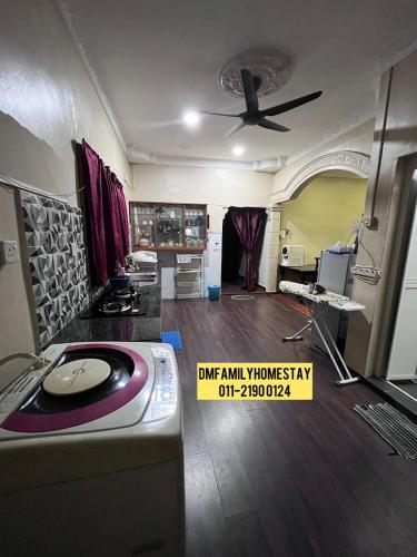 a room with a ceiling fan and a living room at Dmfamilyhomestay in Muar