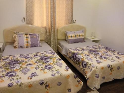 two beds sitting next to each other in a room at موني للشقق الفندقية in Qabāʼ