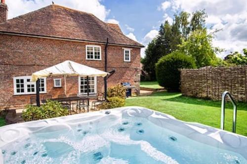 a hot tub in the yard of a house at Wilksworth Caravan Park in Wimborne Minster