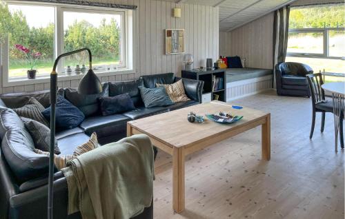 a living room with a couch and a table at Lovely Home In Hadsund With Sauna in Haslevgårde