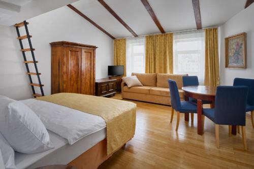 a bedroom with a bed and a table and a couch at La Fenice in Prague