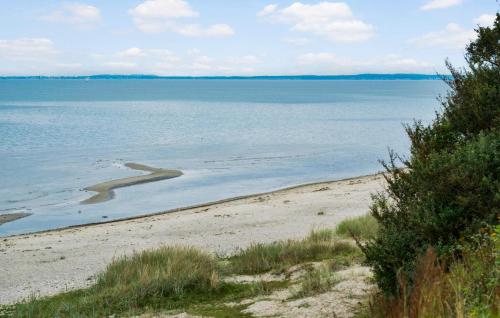 a view of a beach with the ocean in the background at Nice Home In Dronningmølle With Sauna in Firhøj