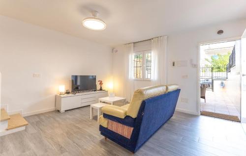 un salon avec une chaise bleue et une télévision dans l'établissement 3 Bedroom Awesome Home In Puerto De Mazarrón, à Puerto de Mazarrón