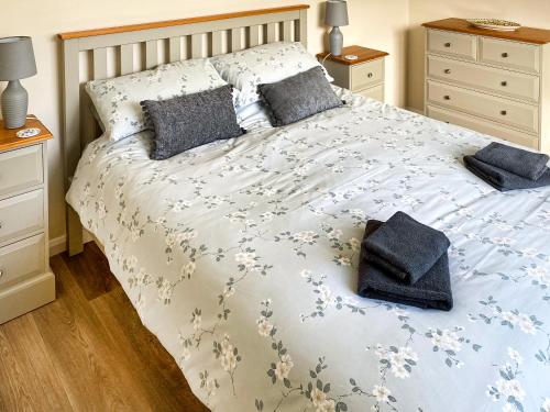 a bedroom with a bed with blue and white sheets and pillows at Ivy - Uk47373 in Burgh le Marsh