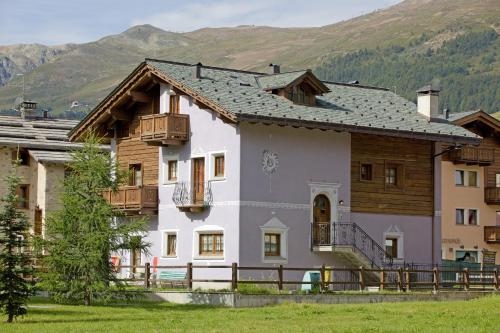 a large white house with a mountain in the background at Appartamenti Lea Pontiglia in Livigno