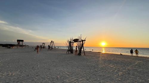 a group of people on the beach at sunset at Hotel Wayira Beach by On vacation in Ríohacha