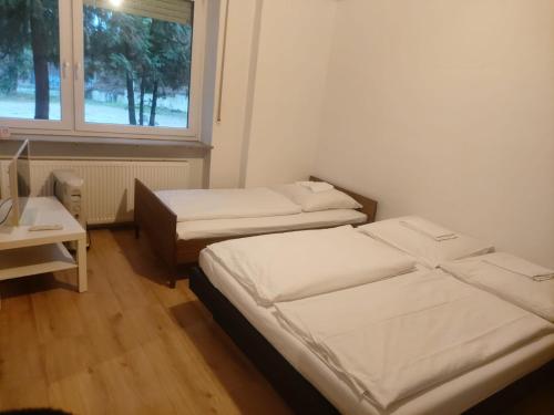 twee bedden in een kleine kamer met een raam bij Hotel 3H Mannheim in MHG