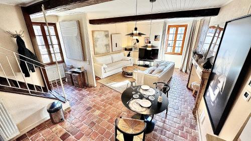 a living room with a table and a couch at Maison Coup de Cœur in Beaune