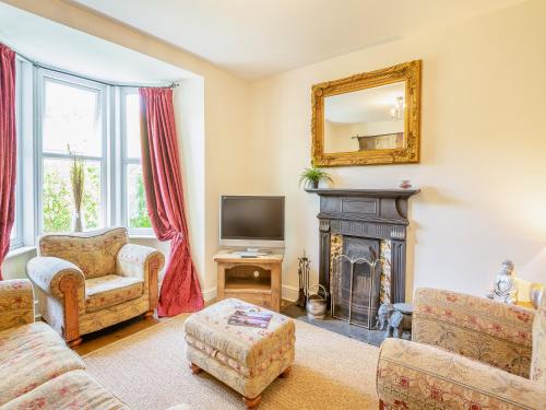 un salon avec une cheminée et un miroir dans l'établissement Cartref, à Capel-Curig